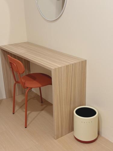 a desk with a chair and a bowl under it at Easy hostel-hotel, 1 min from train station in Hat Yai