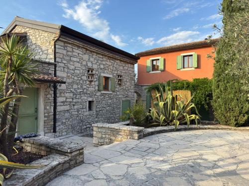 a stone house with a driveway in front of it at Relais Borgo San Nicolò in Umag