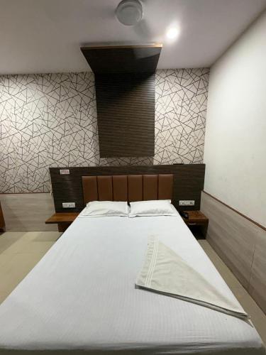 a bedroom with a large bed with white sheets at Hotel Savera in Nale Sopāra