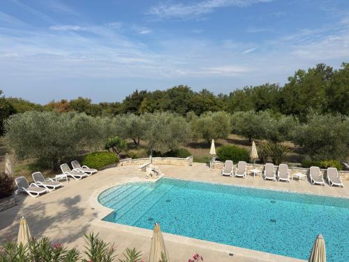 a swimming pool with chaise lounge chairs and a pool at Relais Borgo San Nicolò in Umag