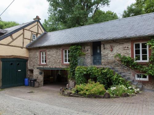 a brick house with a garage and a driveway at Mosel Mill Garden Stay in Maring-Noviand