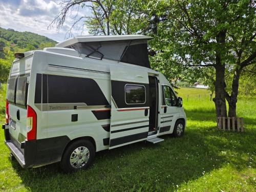 a white camper van parked in a field at Camper Montenegro and Recreational Vehicles in Budva