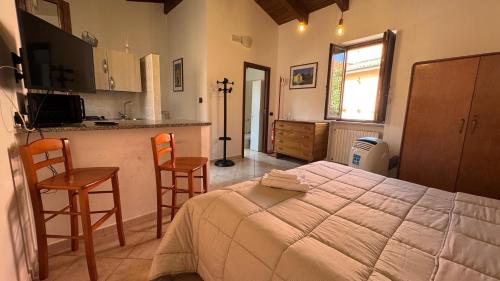a bedroom with a large bed and a kitchen at Porta Nuova Room Locazione Breve Turistica in Benevento