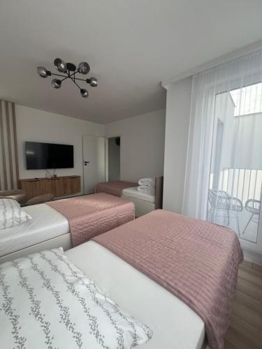 a hotel room with two beds and a television at WRZOSOVA APARTMENT Tarnów in Tarnów