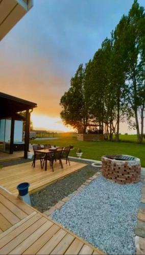 a deck with a picnic table and a fire pit at Köpingebro in Köpingebro