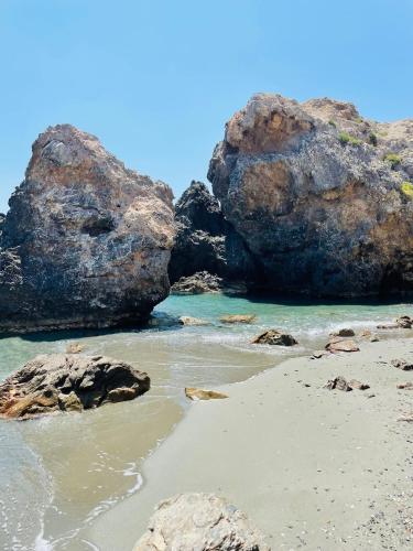 a beach with large rocks in the water at Meer an Oliven in Agia Galini