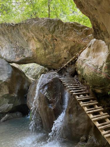 a wooden staircase leading to a waterfall next to a river at Meer an Oliven in Agia Galini