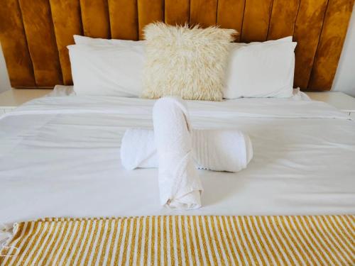 a white bed with white sheets and pillows at Mthiyane Dam View in Hartbeespoort