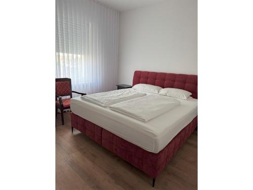 a bed with a red headboard in a room at Hotel & Restaurant Frechen in Frechen