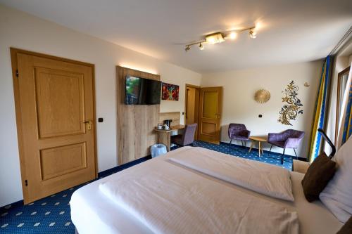 a hotel room with a bed and a table and chairs at Gästehaus Forellenhof in Pottenstein