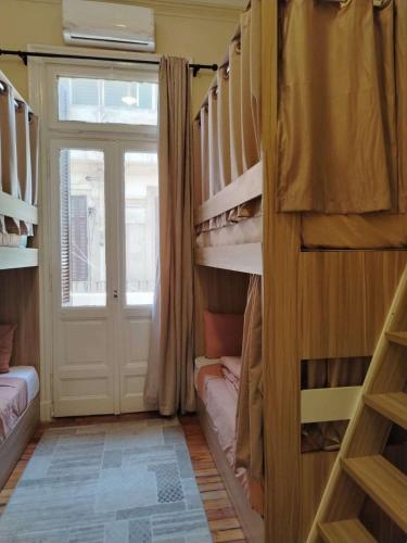a room with bunk beds with a door and a window at Tahrir Palace in Cairo