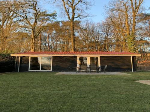 a log cabin with a table and chairs in a yard at Holiday Home in Hellendoorn near Forest in Hellendoorn