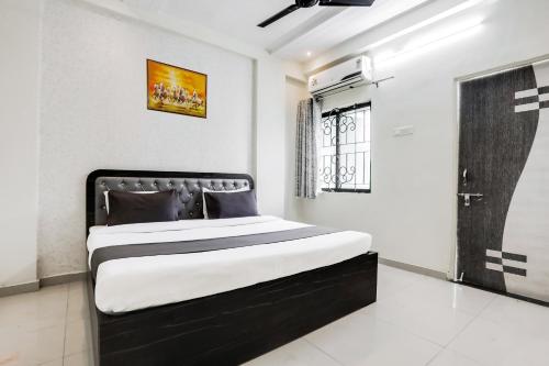 a bedroom with a black and white bed and a window at Hotel O Grand Trinity in Nagpur