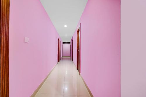 a corridor with white walls and a long hallway with red doors at Super Collection O Harsh Regency in Rānchī