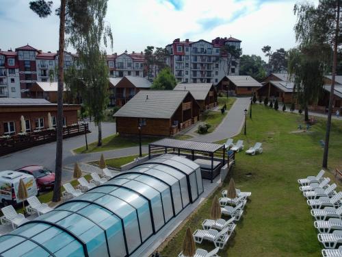 a view of a resort with chairs and a train at Morska Osada domki blisko morza in Krynica Morska