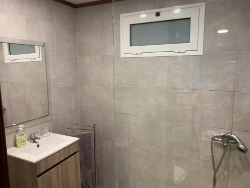 ein Badezimmer mit Waschbecken und einem Fernseher an der Wand in der Unterkunft Casadarvore in Ponta Delgada