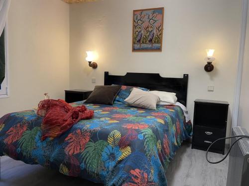 ein Schlafzimmer mit einem Bett mit einer bunten Bettdecke in der Unterkunft Casadarvore in Ponta Delgada