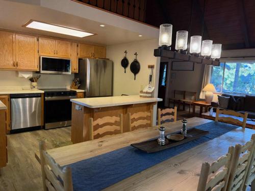 a kitchen and dining room with a wooden table and a kitchen at Blue Lake Chalet- 3 Bedroom + Loft/Pool Table in Arnold/Bear Valley (Pet-Friendly) in Arnold