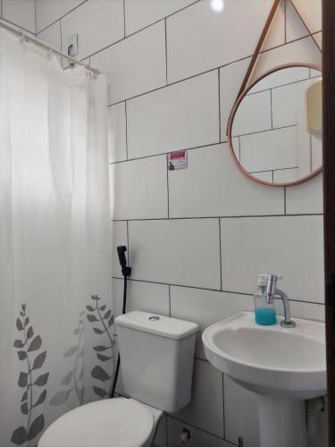 a white bathroom with a toilet and a sink at Casa Monjardim in Vitória