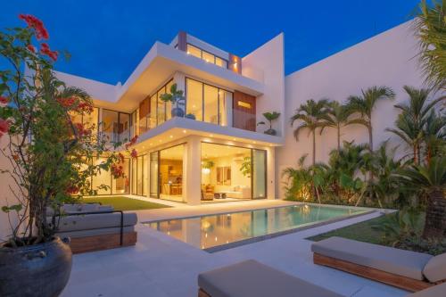 a large house with a swimming pool in front of it at Exclusive 4BR Villa with Rooftop, Ricefield Views near Cemagi Beach in Cemagi