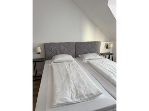 two beds with white sheets and pillows in a room at Hotel & Restaurant Frechen in Frechen