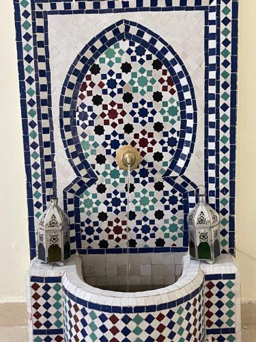 a mosaic fountain with two clocks in front of it at Appartement 4 personnes in Amizmiz