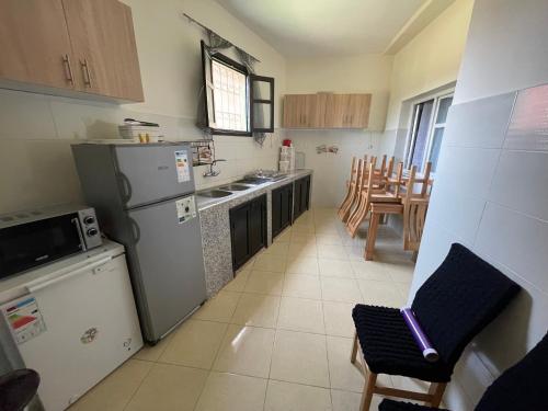 a kitchen with a refrigerator and a table and chairs at Appartement 4 personnes in Amizmiz