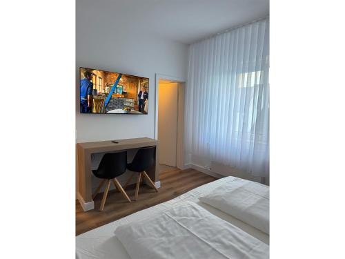 a bedroom with a bed and a desk with two chairs at Hotel & Restaurant Frechen in Frechen