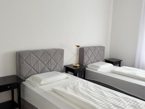 two twin beds in a room with two tables at Hotel & Restaurant Frechen in Frechen
