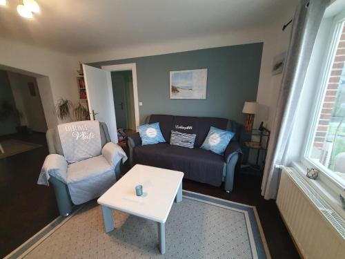 a living room with two chairs and a coffee table at Ferienhaus am Nordostseekanal in Offenbüttel