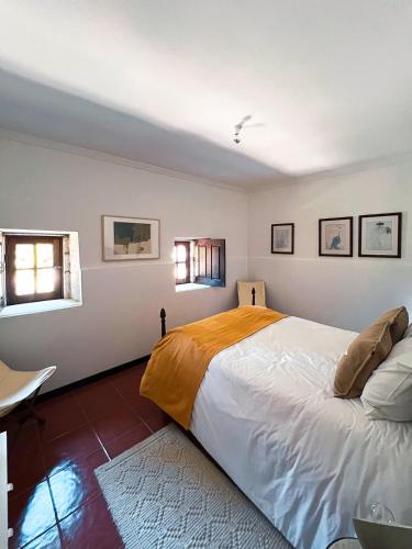 a bedroom with a large bed and two windows at Quinta da Faísca Guesthouse in Vila do Conde