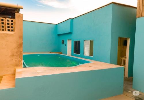 a blue house with a swimming pool at Pousada Caravela in Penha