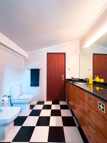 a bathroom with a black and white checkered floor at Quinta da Faísca Guesthouse in Vila do Conde