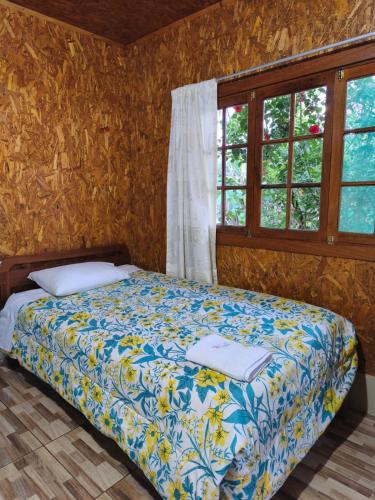 a bedroom with a bed and two windows at Hospedaje Cattleya in Oxapampa