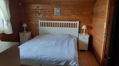 a bedroom with a white bed and two night stands at Chalet familial au cœur de la Haute Savoie in La Roche-sur-Foron
