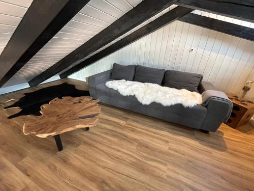 a living room with a couch and a wooden table at Direkt am See mit privatem Sandstrand in Güster