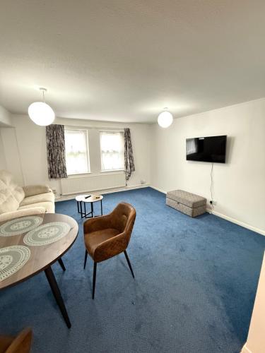 a living room with a table and a couch at 262-280 Apartments in Headingley