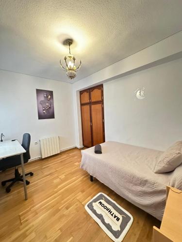 a bedroom with a bed and a desk and a table at Habitacion céntrica cómoda in Granada