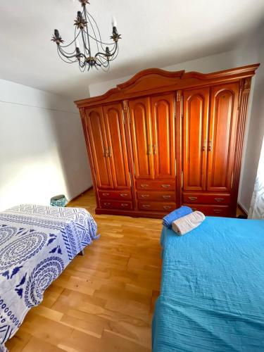a bedroom with a bed and a wooden cabinet at Habitacion céntrica cómoda in Granada