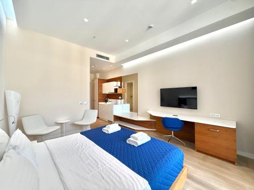 a bedroom with a blue bed and a tv at Condo Studio Plaza in Budva