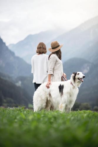 two women standing on a hill with a dog at OVINA`s HAUS in Sand in Taufers