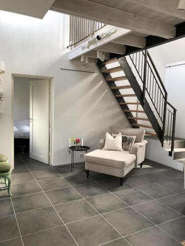 a living room with a chair and a staircase at Charmigt havsnära boende på Österlen in Simrishamn