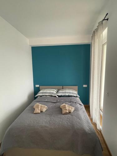a bedroom with a large bed with a blue wall at Riverside Apartment Szeged in Szeged