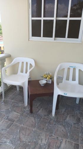 two white chairs and a table in a room at Habitación Taina in Jarabacoa