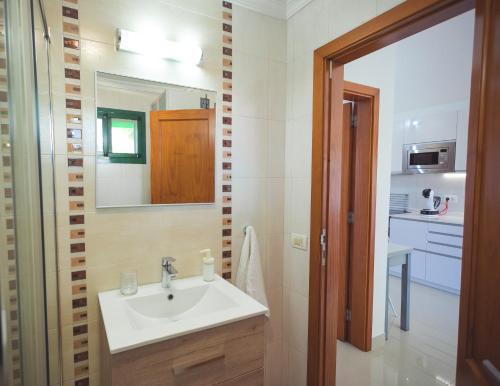a bathroom with a sink and a mirror at Ahtha Green Bungalow Maspalomas in San Bartolomé de Tirajana
