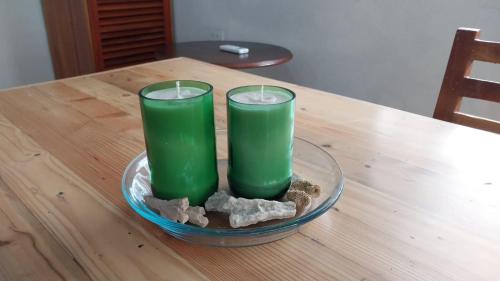 two green candles sitting on a glass bowl on a table at Genovesa Family home in Puerto Ayora