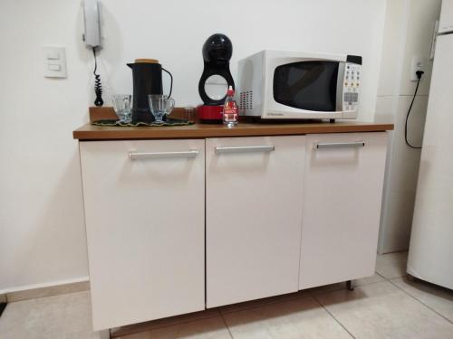 une cuisine avec des armoires blanches et un micro-ondes dans l'établissement Studio Premium, à Franca