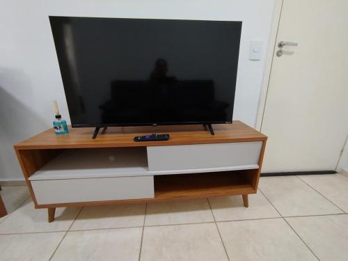 a flat screen tv on a wooden entertainment center at Studio Premium in Franca