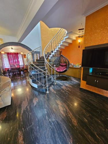 a living room with a spiral staircase in a house at Homestay near Kochi Airport in Ernakulam