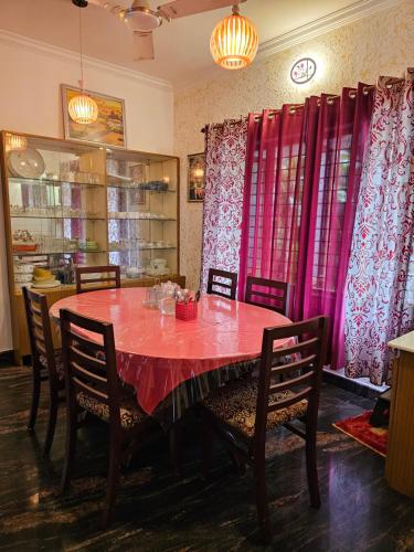 a dining room with a red table and chairs at Homestay near Kochi Airport in Ernakulam